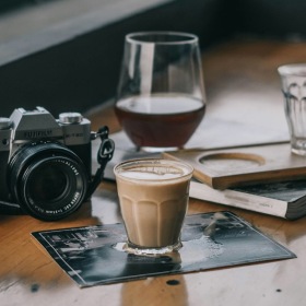 a camera and cup of coffee on a table